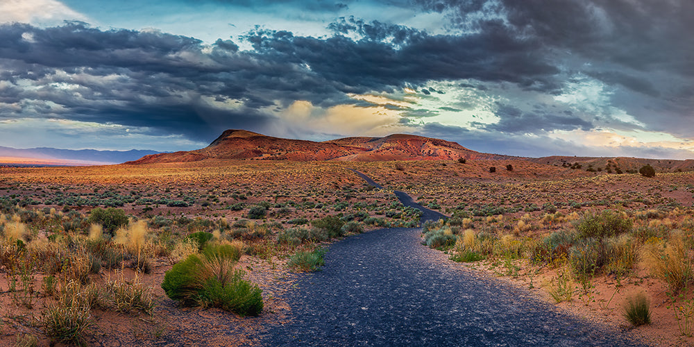 colorful dry desert at sunset with a road in between